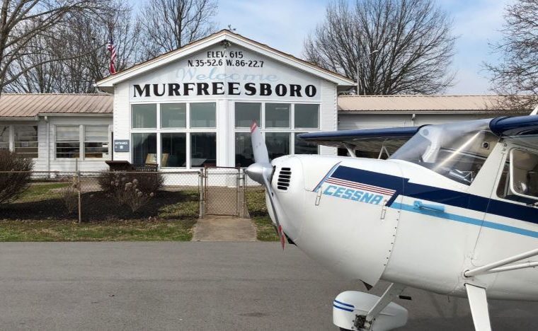 Murfreesboro Municipal Airport. Building with a Murfreesboro sign and a plane in front of it on the pavement.