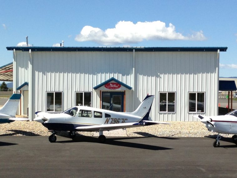 Deer Park Air Center building with 3 small aircraft parked in front in a row.