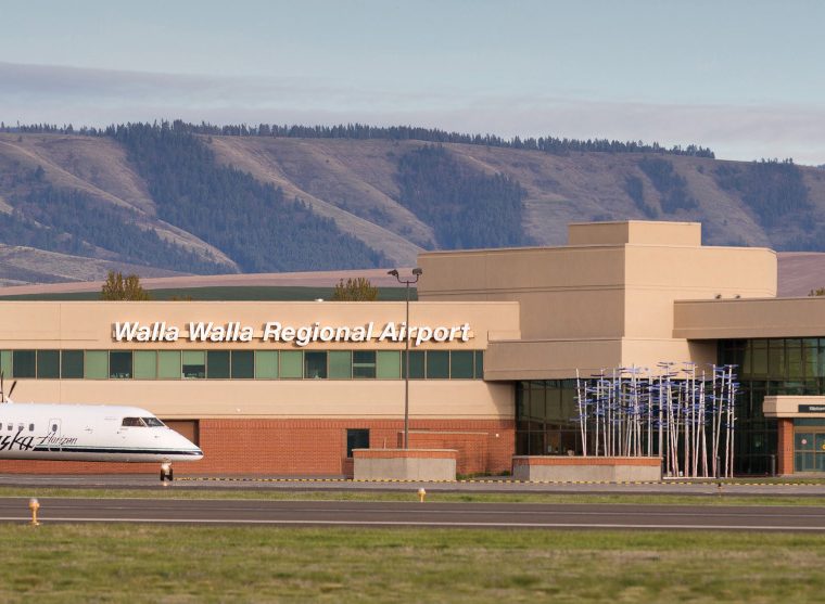Walla Walla Regional Airport terminal building with a jet out front and mountains behind.